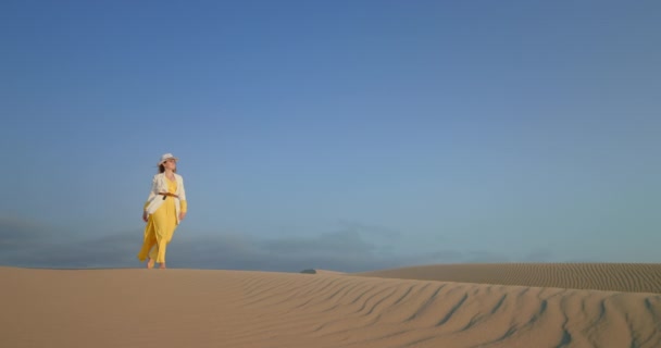 Snygg kvinna promenader i fashionabla kläder av den porlande sand öken yta — Stockvideo