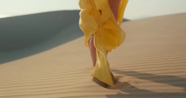 Закрыть кинематографическое замедленное движение женщины, идущей по песку с волнистым рисунком — стоковое видео