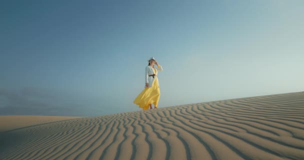 Mujer de cámara lenta en elegante traje de safari es ondulado textura arena desierto superficie — Vídeos de Stock