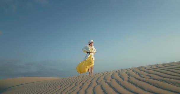 Slow motion kvinna i snygg safari outfit är vågig texturerad sand öken yta — Stockvideo