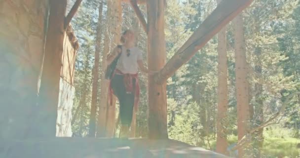 Wanderin läuft an der Veranda eines steinernen Jagdschlosses im grünen Wald vorbei — Stockvideo