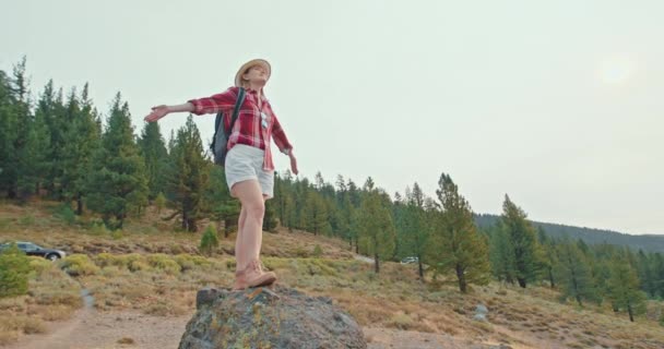 Hipster millenium młoda kobieta w czerwonej koszuli w kratę pobyt na wzgórzu w pochmurny dzień — Wideo stockowe