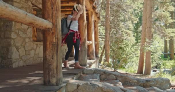 Mujer sonriente caminando desde la casa del bosque en la naturaleza de otoño. Turista disfrutando otoño — Vídeo de stock