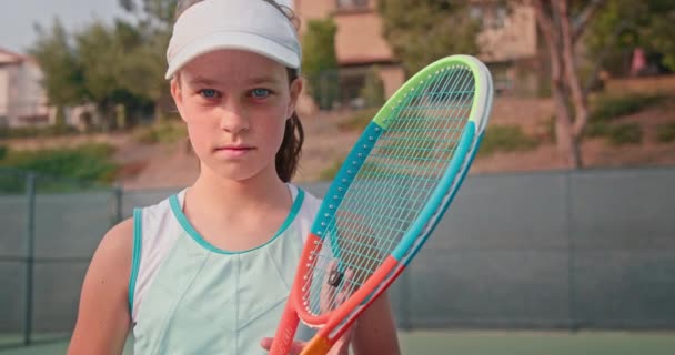 10代のテニス選手。アスリート女の子見ます上のカラフルな明るいテニスラケット — ストック動画