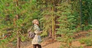 Gezgin kadın Yeşil Dağ Ormanı 'ndaki fotoğraf makinesinde fotoğraf çekiyor, 4K