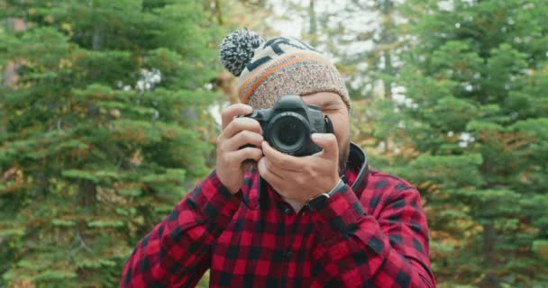 英俊的男人用相机拍专业的照片。盖伊拍摄绿色森林 — 图库视频影像