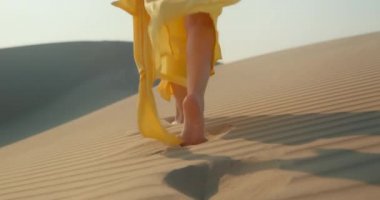 Dalgalı kum tepeciğinin yanından geçen ince kadın bacaklarının modaya uygun yakın görüntüsü
