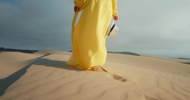 Close-up mulher em amarelo elegante vestido de moda andando descalço por duna ondulada — Vídeo de Stock