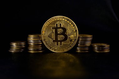 yığınlar sikke ve bir altın sikke bitcoin siyah deri üzerinde arasında