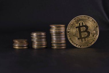 Üç yığınları sikke sipariş ve bir altın sikke bitcoin siyah deri üzerinde artan