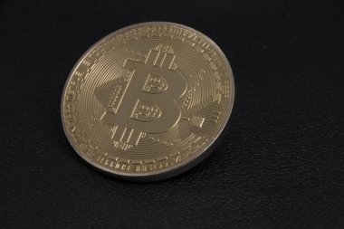 altın sikke bitcoin siyah deri üzerinde