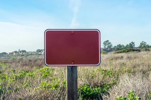 Close up image of an empty sign with copy space, dry grass on the background on a sunny day; State park, California, USA
