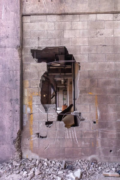 Bir duvar bir terk edilmiş yıkık binada bir düzensiz şekil deliği görüyor birkaç farklı oda