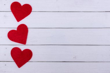 Beyaz Saint Valentine's gün arka plan kopya alanı sol tarafında üç kırmızı kalpler ile. Aşk, aşk kavramı, üstten görünüm, düz sembolü yatıyordu