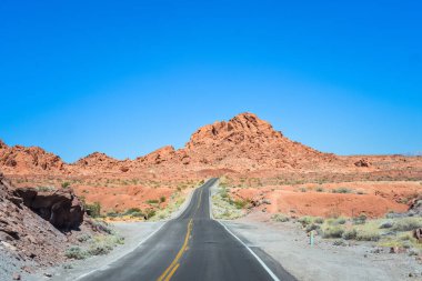 Dağlara doğru ufukta çalıştıran çöl yoluyla iki şeritli bir yol. Özgürlük ve seyahat kavramı arka plan kopya alanı ile ruhu.