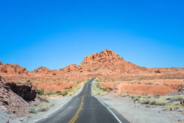 Dağlara doğru ufukta çalıştıran çöl yoluyla iki şeritli bir yol. Özgürlük ve seyahat kavramı arka plan kopya alanı ile ruhu.