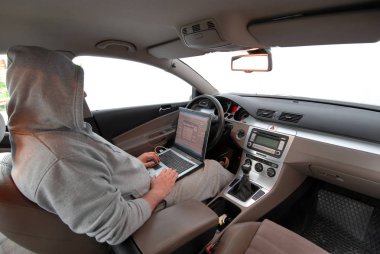adam bir arabada oturan bir laptop üzerinden veri çalmak