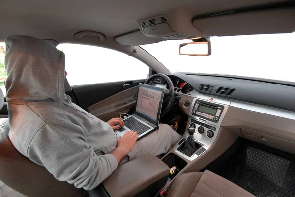 adam bir arabada oturan bir laptop üzerinden veri çalmak