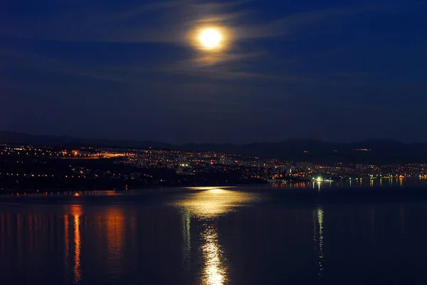 town on the coast at night with moon