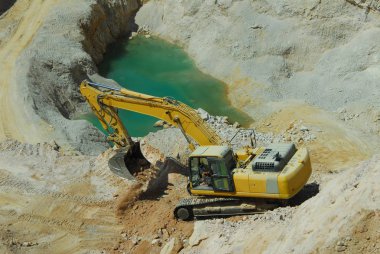 büyük sarı yükleyici büyük bir taş ocağında taşır.