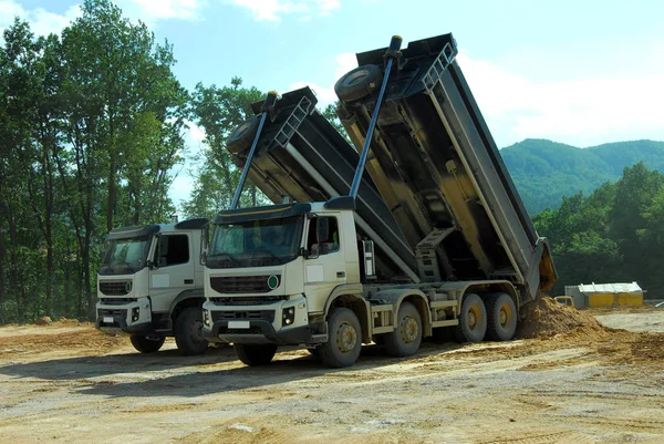 two tipper truck unloading land on the site