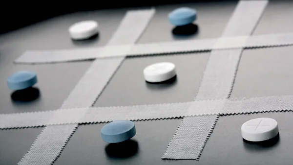 Pill medicines on table. Tic tac toe.