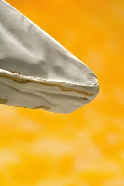 Camembert peyniri, sarı arka planda küflü peynir..