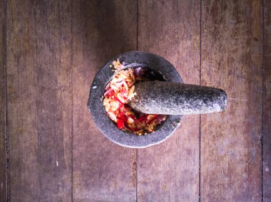 Kahverengi ahşap katlarda taş havan Tay baharat