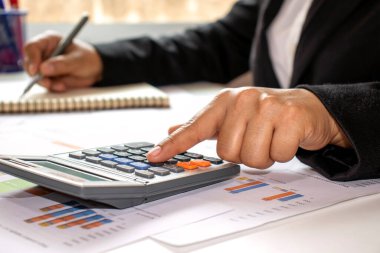 Kadınların kendi evlerinin penceresinde muhasebe raporları oluşturmak için hesap makineleri kullanmaları, maliyet hesaplama kavramları ve ev kavramlarında çalışmaları..