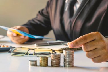 Para yığını üzerinde bozuk para tutan bir işadamı..