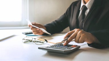 Finans işçileri, şirket karlarını hesaplıyorlar. Evdeki masalarının üzerindeki çizelgelerden, finansal fikirlerden ve denetlemelerden..