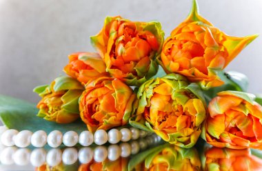 Güzel turuncu laleler ve aynaya beyaz inci. Mükemmel 