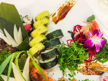 Beyaz plaka üzerinde suşi rulo çeşitliliği