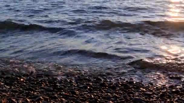 島や山々と地中海沿岸の美しい夕日 太陽の光で照らされたビーチの波と石 — ストック動画