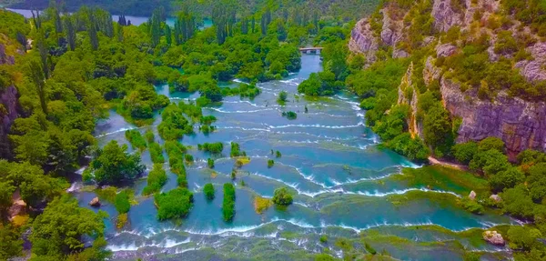 Şelale manzaralı turkuaz su, Plitvice Gölleri Ulusal Parkı 'nda güneşli ışınlar. Orman gün ışığıyla parıldıyor. Hırvatistan. Avrupa. 2019
