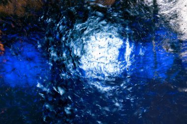 Küçük kabarcıklar beyaz ve mavi ışıkla aydınlatılmış açık şeffaf buzlu. Buzun yapısını fantastik desenler oluşturur.