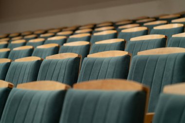 Yeşil döşeme ile döşemeli koltuklar. Boş oditoryum. Ahşap sandalyeler.