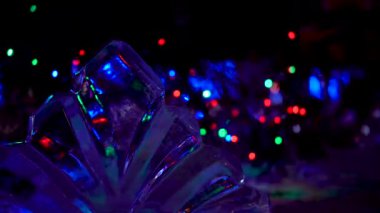 Yeni yıl. Noel. Kutlama. Güzel bokeh şeklinde renkli ışıklar aydınlatma. Şeffaf buz heykeli.