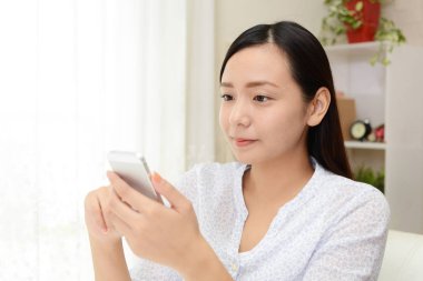 Bir akıllı telefon kullanan gülümseyen kadın