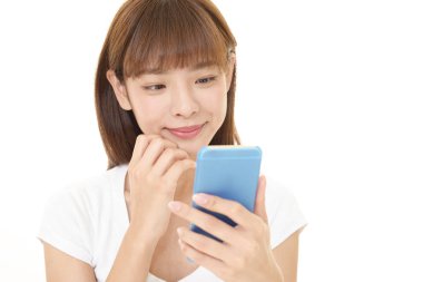 Bir akıllı telefon kullanan gülümseyen kadın