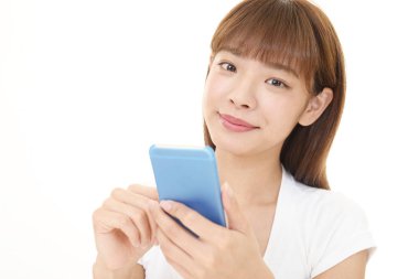 Bir akıllı telefon kullanan gülümseyen kadın