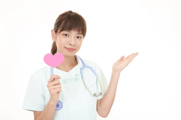 Smiling Asian Nurse Holding Pink Heart Love Symbol — Stock Photo, Image