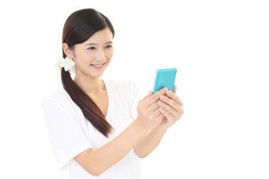 Bir akıllı telefon kullanan gülümseyen kadın