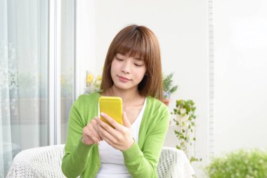 Bir akıllı telefon kullanan gülümseyen kadın