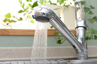 Paslanmaz çelik mutfak musluk ve lavabo akan su ile