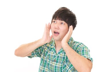 Şaşırmış Asyalı adam beyaz arka planda izole edilmiş.