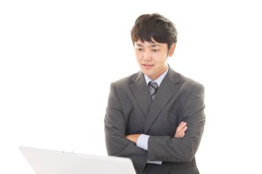 bir dizüstü bilgisayar kullanarak gülümseyen iş adamı