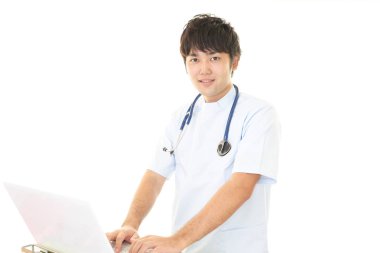 Dizüstü bilgisayarda çalışan doktor. Beyaz izole.