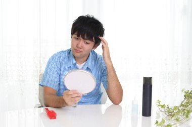 Adam saçlarıyla mutsuz görünüyor.