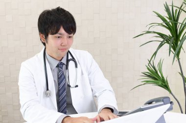 Doktor dizüstü bilgisayarda çalışıyor.